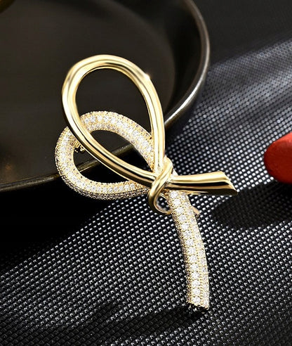 elegancka BROSZKA ozdoba do ubrań WSTĄŻKA cyrkonie kolor złoty na prezent